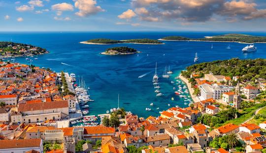 Hvar town and harbor with yachts anchored around the Pakleni Islands in Croatia.