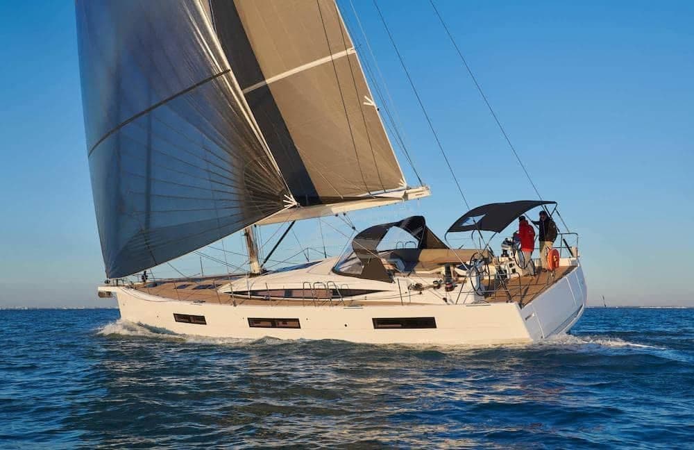A large cruising yacht under full sail in evening light