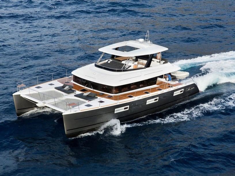 A flybridge power catamaran under way in open water