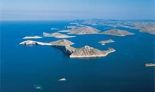 Aerial view of the bare stone islands of the Kornati archipelago scattered across deep blue sea