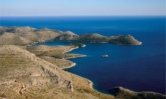 The almost enclosed bay of Skrivena Luka on Lastovo seen from the hillside, with the Struga lighthouse on the headland beyond