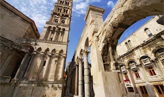 The peristyle of Diocletian's Palace in Split, with the cathedral bell tower rising behind the Roman columns